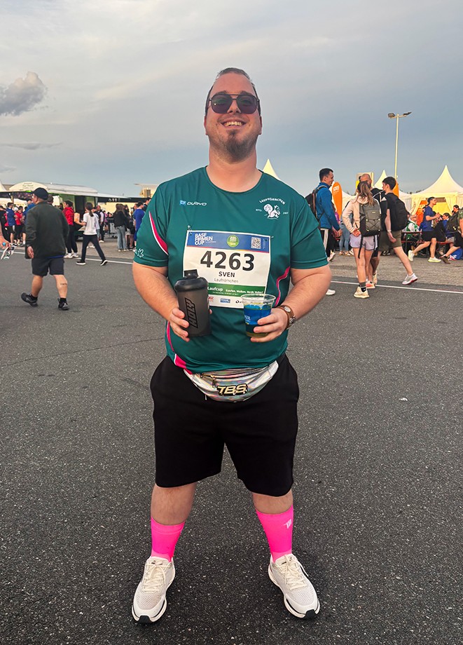Sven mit seiner Startnummer auf dem Shirt und Getränken in der Hand