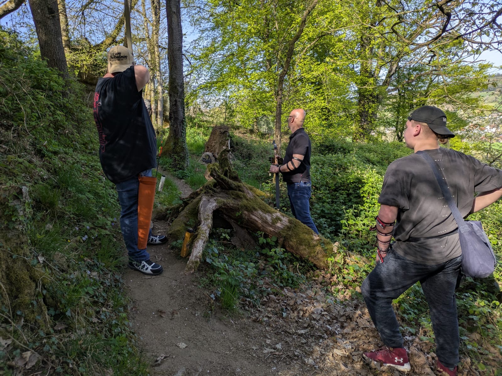 Eine Gruppe von Männern steht auf einem Waldweg.